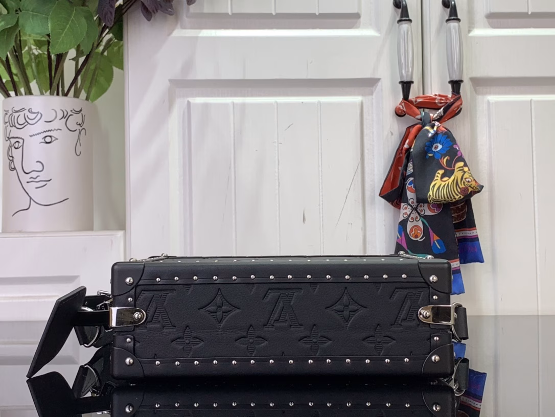The Clutch Box handbag pays tribute to Louis Vuitton's box-making heritage with Monogram Shadow embossed leather, and is paired with a detachable and adjustable fabric shoulder strap, which can be easily switched between shoulder and crossbody. Leather trim, metal rivets and S-lock buckle convey a modern style, and there are accordion compartments and patch pockets inside.