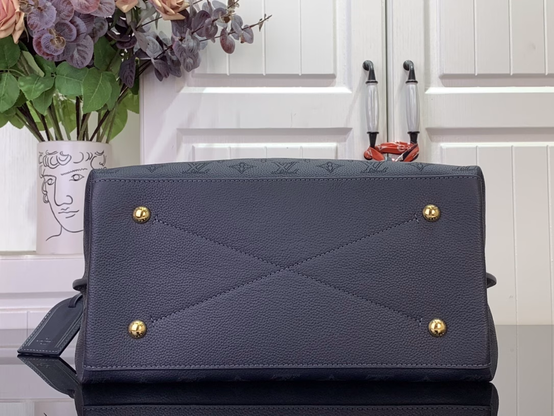 This elegant Carmel tote is crafted from Mahina calfskin leather, delicately perforated with the brand's signature monogram. Perfectly sized for everyday essentials, including a laptop, the versatile design features a removable LV braided leather charm. Note the address label, which pays homage to traditional Louis Vuitton trunks.