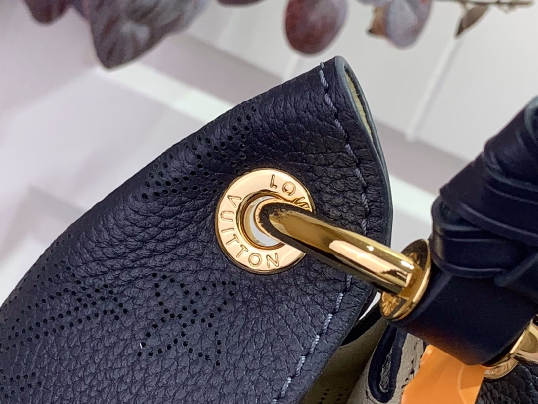 This elegant Carmel tote is crafted from Mahina calfskin leather, delicately perforated with the brand's signature monogram. Perfectly sized for everyday essentials, including a laptop, the versatile design features a removable LV braided leather charm. Note the address label, which pays homage to traditional Louis Vuitton trunks.