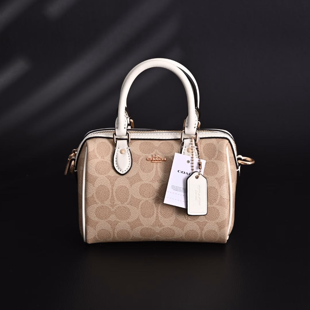 Coach Rowan Mini Boston Bag Crossbody HandbagClassic Print Zipper Closure - Coated Canvas - Crossbody Handbag - Mini Women's - Vanilla White! My first light luxury bag in my life. After working, I thought I should buy myself a practical and beautiful bag. The Coach Boston bag is really beautiful after I got it! I especially like the vanilla white color. The color of the handle and the side print is the same, which looks very high-end! The bag is bulging and stylish, and the capacity is enough to hold daily necessities. It is suitable for both hand-held and cross-body. This color scheme makes you look more gentle and elegant in autumn and winter!