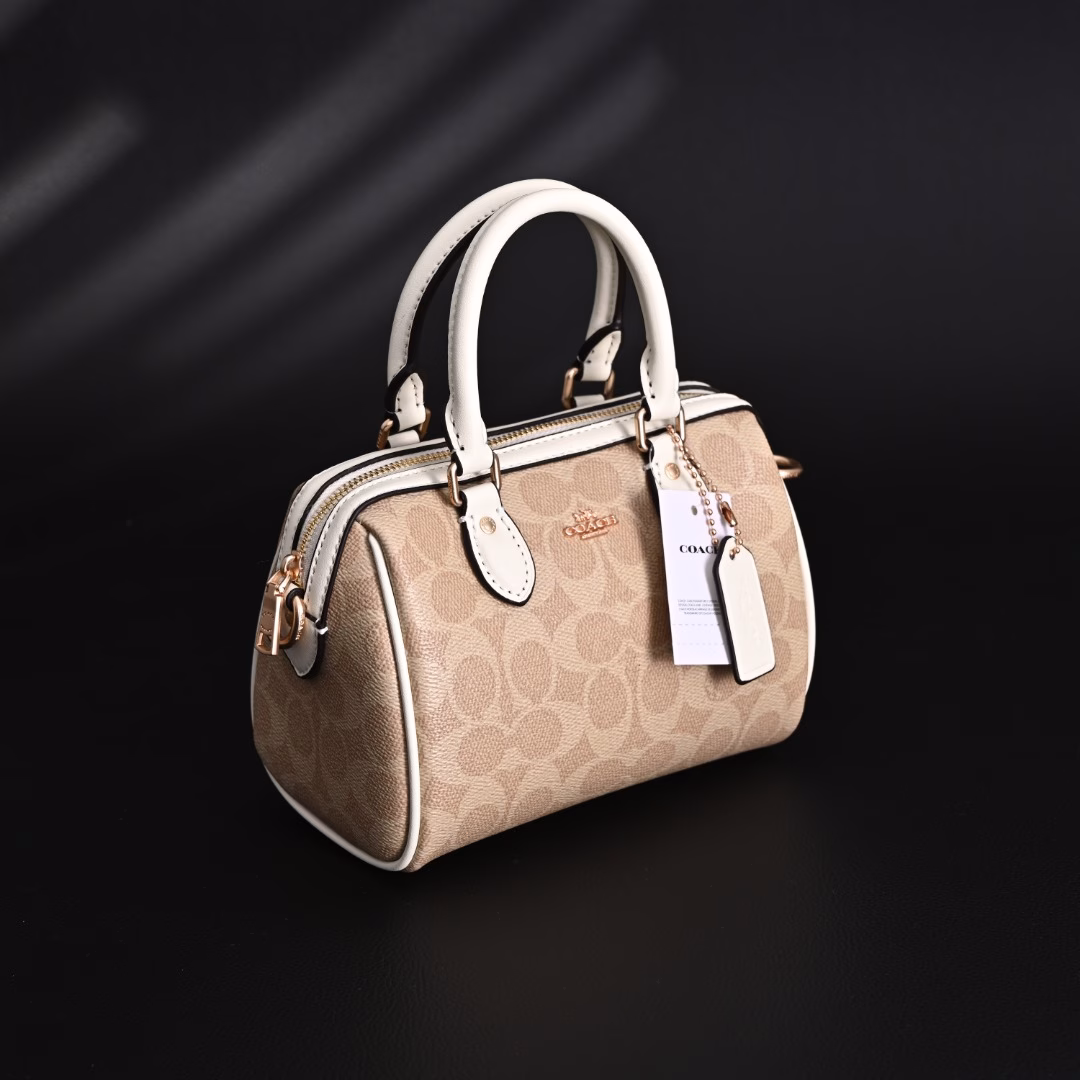 Coach Rowan Mini Boston Bag Crossbody HandbagClassic Print Zipper Closure - Coated Canvas - Crossbody Handbag - Mini Women's - Vanilla White! My first light luxury bag in my life. After working, I thought I should buy myself a practical and beautiful bag. The Coach Boston bag is really beautiful after I got it! I especially like the vanilla white color. The color of the handle and the side print is the same, which looks very high-end! The bag is bulging and stylish, and the capacity is enough to hold daily necessities. It is suitable for both hand-held and cross-body. This color scheme makes you look more gentle and elegant in autumn and winter!