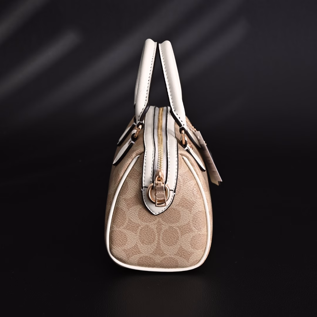 Coach Rowan Mini Boston Bag Crossbody HandbagClassic Print Zipper Closure - Coated Canvas - Crossbody Handbag - Mini Women's - Vanilla White! My first light luxury bag in my life. After working, I thought I should buy myself a practical and beautiful bag. The Coach Boston bag is really beautiful after I got it! I especially like the vanilla white color. The color of the handle and the side print is the same, which looks very high-end! The bag is bulging and stylish, and the capacity is enough to hold daily necessities. It is suitable for both hand-held and cross-body. This color scheme makes you look more gentle and elegant in autumn and winter!
