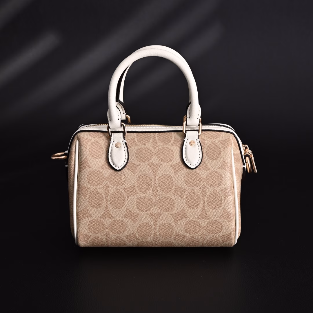 Coach Rowan Mini Boston Bag Crossbody HandbagClassic Print Zipper Closure - Coated Canvas - Crossbody Handbag - Mini Women's - Vanilla White! My first light luxury bag in my life. After working, I thought I should buy myself a practical and beautiful bag. The Coach Boston bag is really beautiful after I got it! I especially like the vanilla white color. The color of the handle and the side print is the same, which looks very high-end! The bag is bulging and stylish, and the capacity is enough to hold daily necessities. It is suitable for both hand-held and cross-body. This color scheme makes you look more gentle and elegant in autumn and winter!