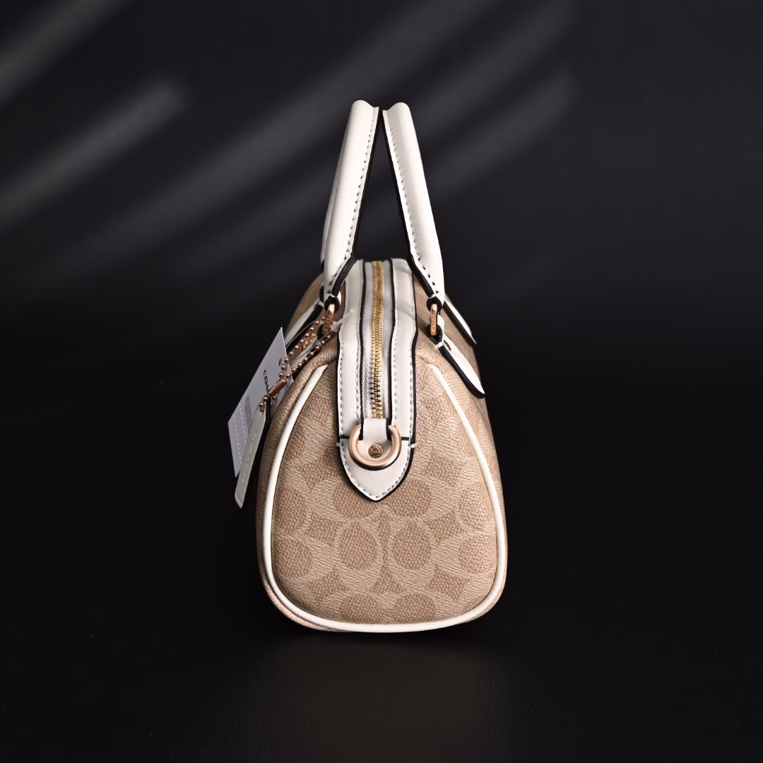 Coach Rowan Mini Boston Bag Crossbody HandbagClassic Print Zipper Closure - Coated Canvas - Crossbody Handbag - Mini Women's - Vanilla White! My first light luxury bag in my life. After working, I thought I should buy myself a practical and beautiful bag. The Coach Boston bag is really beautiful after I got it! I especially like the vanilla white color. The color of the handle and the side print is the same, which looks very high-end! The bag is bulging and stylish, and the capacity is enough to hold daily necessities. It is suitable for both hand-held and cross-body. This color scheme makes you look more gentle and elegant in autumn and winter!