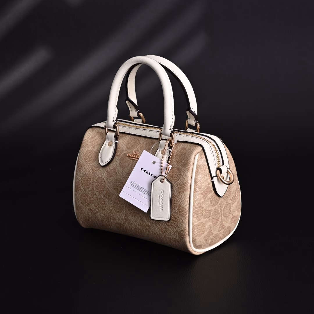 Coach Rowan Mini Boston Bag Crossbody HandbagClassic Print Zipper Closure - Coated Canvas - Crossbody Handbag - Mini Women's - Vanilla White! My first light luxury bag in my life. After working, I thought I should buy myself a practical and beautiful bag. The Coach Boston bag is really beautiful after I got it! I especially like the vanilla white color. The color of the handle and the side print is the same, which looks very high-end! The bag is bulging and stylish, and the capacity is enough to hold daily necessities. It is suitable for both hand-held and cross-body. This color scheme makes you look more gentle and elegant in autumn and winter!