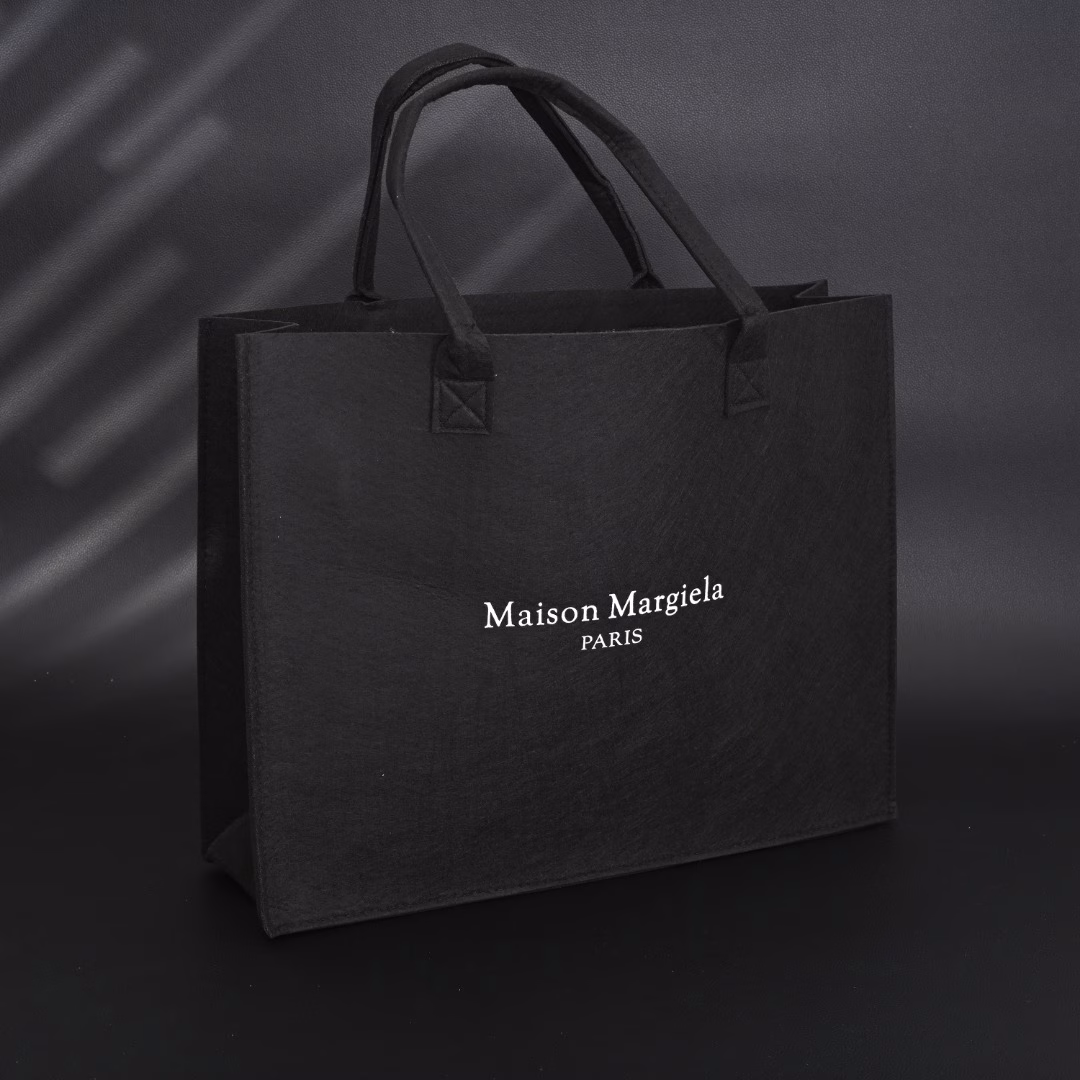 Maison Margiela MM6 Belgian Limited Edition Tote BagUsing 140g HM imported felt, one-piece singeing process, the whole bag weighs only 300g, freeing shoulders and hands. The printed film board is scraped 4 times, which contrasts strongly with the overall elegant black. Produced by a large factory, perfect details, all sizes are in stock.