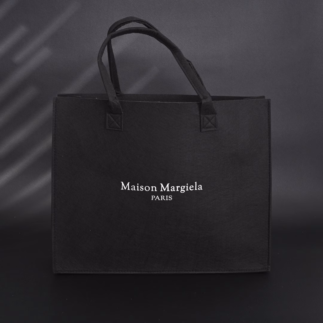 Maison Margiela MM6 Belgian Limited Edition Tote BagUsing 140g HM imported felt, one-piece singeing process, the whole bag weighs only 300g, freeing shoulders and hands. The printed film board is scraped 4 times, which contrasts strongly with the overall elegant black. Produced by a large factory, perfect details, all sizes are in stock.