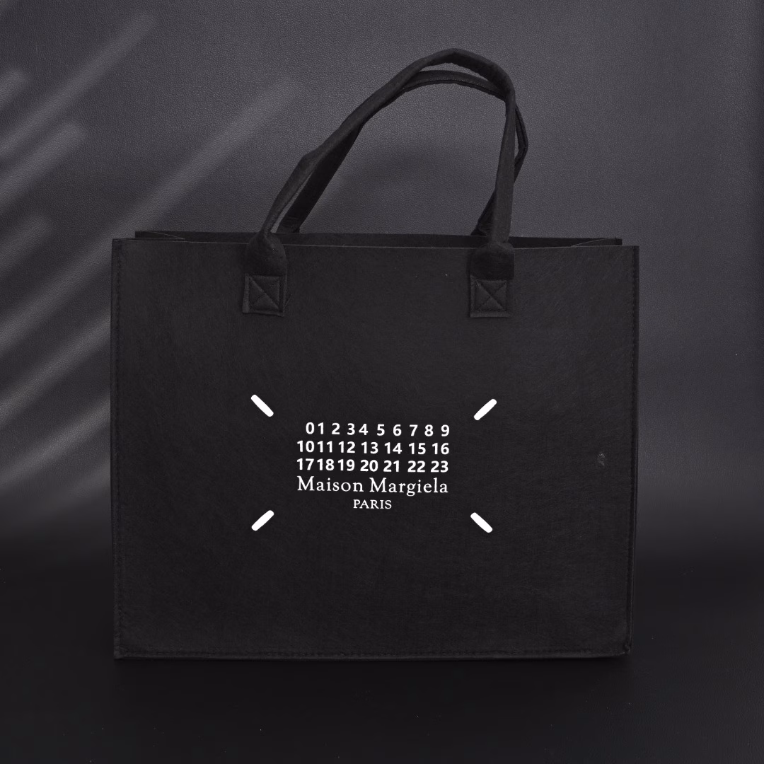 Maison Margiela MM6 Belgian Limited Edition Tote BagUsing 140g HM imported felt, one-piece singeing process, the whole bag weighs only 300g, freeing shoulders and hands. The printed film board is scraped 4 times, which contrasts strongly with the overall elegant black. Produced by a large factory, perfect details, all sizes are in stock.