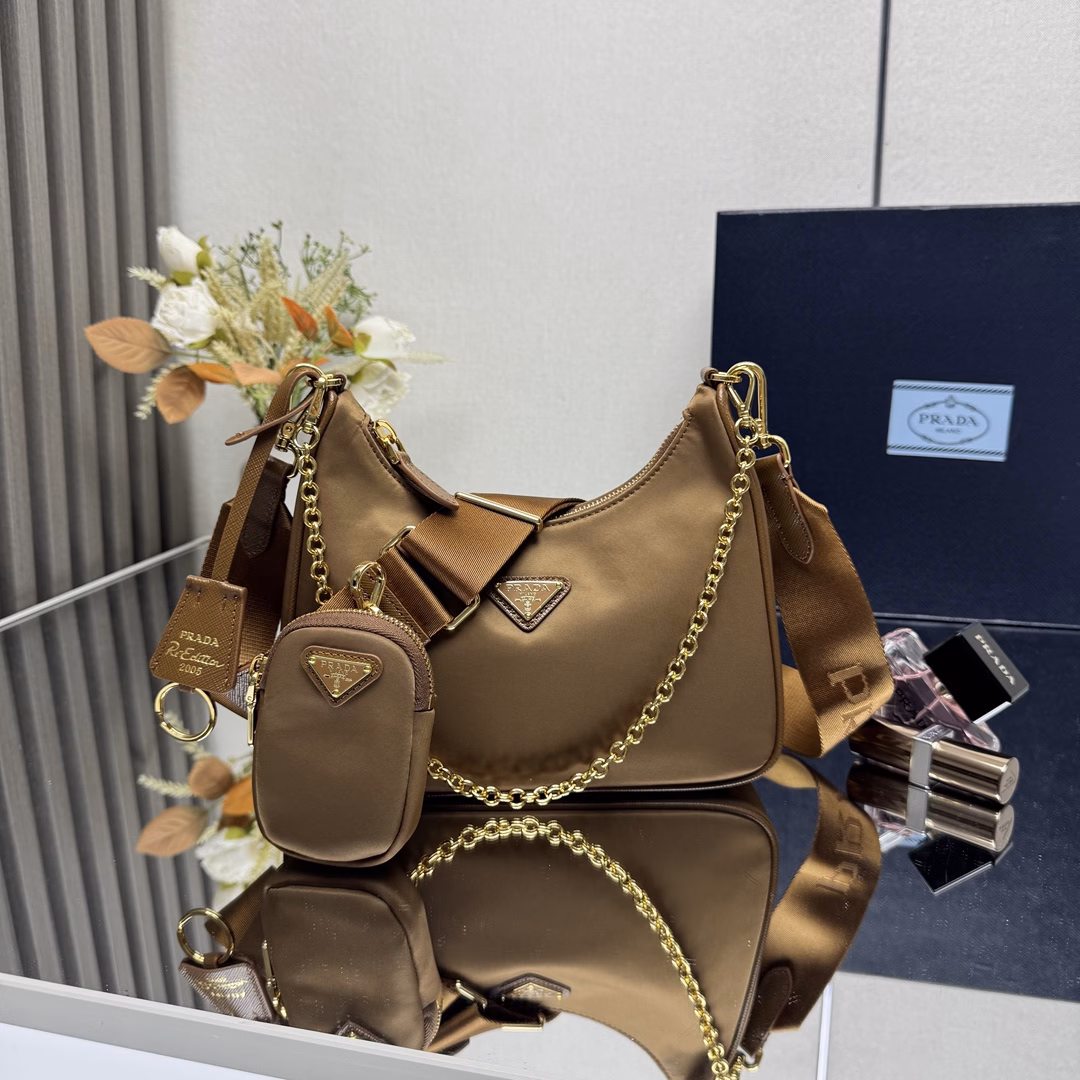 Prada's new nylon Hobo handbag/gold hardware underarm bag😘😘The hobo that has swept the fashion circle with the crazy promotion of the Internet celebrity sister group has a new model! 👏👏The design of this Hobo bag is great👍👍One bag with three uses😘😘Waist bag/crossbody/single shoulder👍👍The handle is replaced with a chain, and the underarm bag has a touch of sexiness. It is also equipped with a long shoulder strap. What I love most is that there is a small pendant (small bag) hanging on the shoulder strap, and other bags and trousers can also be hung as accessories. 🙊🙊It can be matched with various clothes at ordinary times😘😘Babies, hurry up and get it, it's so beautiful