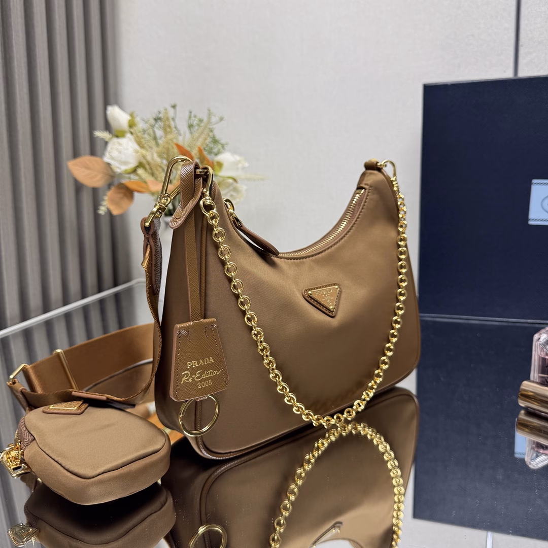 Prada's new nylon Hobo handbag/gold hardware underarm bag😘😘The hobo that has swept the fashion circle with the crazy promotion of the Internet celebrity sister group has a new model! 👏👏The design of this Hobo bag is great👍👍One bag with three uses😘😘Waist bag/crossbody/single shoulder👍👍The handle is replaced with a chain, and the underarm bag has a touch of sexiness. It is also equipped with a long shoulder strap. What I love most is that there is a small pendant (small bag) hanging on the shoulder strap, and other bags and trousers can also be hung as accessories. 🙊🙊It can be matched with various clothes at ordinary times😘😘Babies, hurry up and get it, it's so beautiful