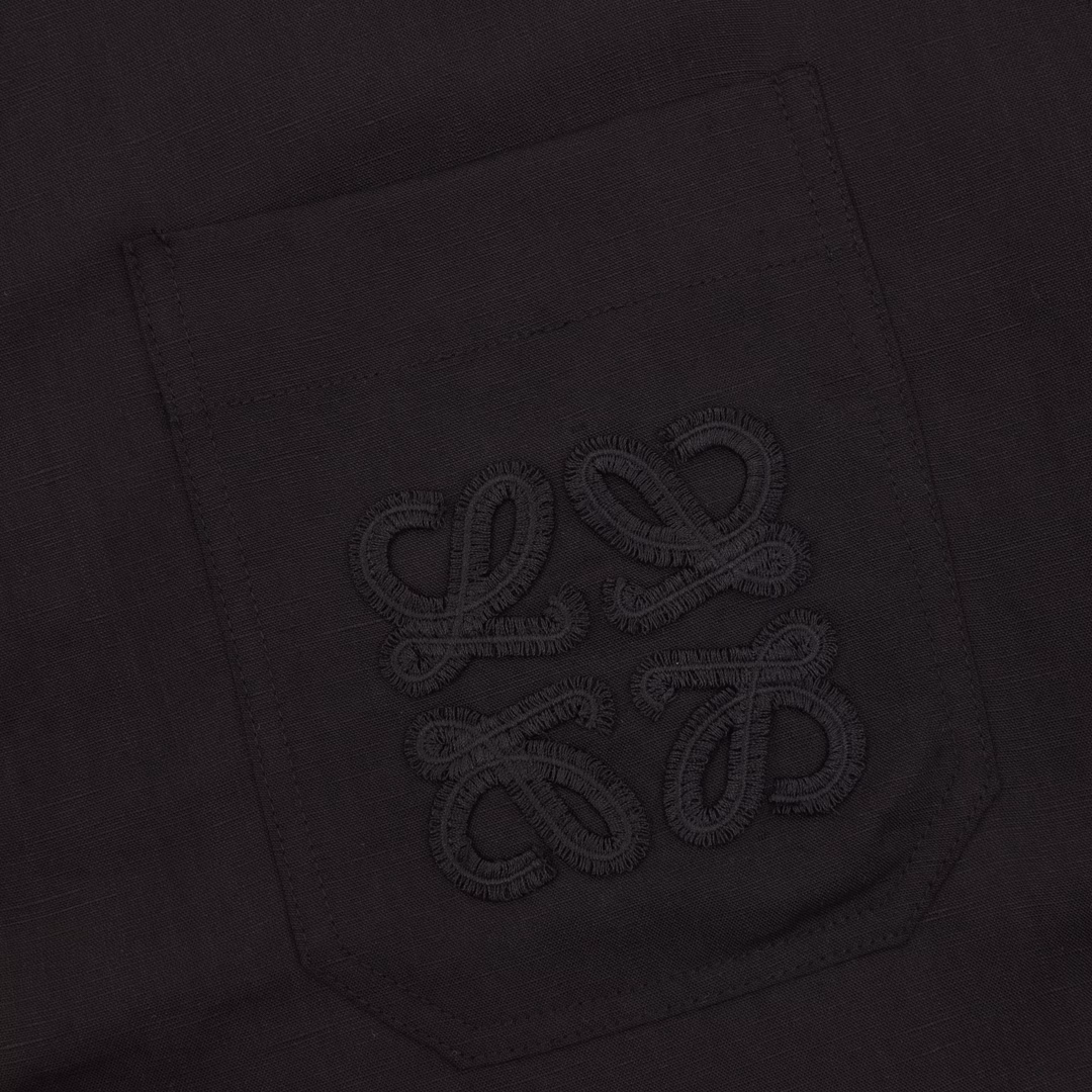 Loewe Pocket Embroidered Linen Short Sleeve ShirtThe fiber is interlocked by air-spinning technology, and the smooth drape of viscose neutralizes the rough texture of linen. The bony support of linen makes up for the shortcoming of viscose's easy deformation. The high moisture absorption rate of viscose is linked with the porous fiber structure of linen to form a dual-channel perspiration system. It has both wrinkle resistance and drape, reflecting the characteristics of the fusion of the two fibers. The Anagram totem on the chest pocket adopts the implicit hook needle embroidery process, and uses extremely fine silk threads to evolve a precise matrix of 320 needles/CM² on the linen base, which resonates with the natural texture of the fabric. The lining is implanted with an anti-stretching mesh backing to ensure that the embroidery remains smooth after frequent use. Customized accessories