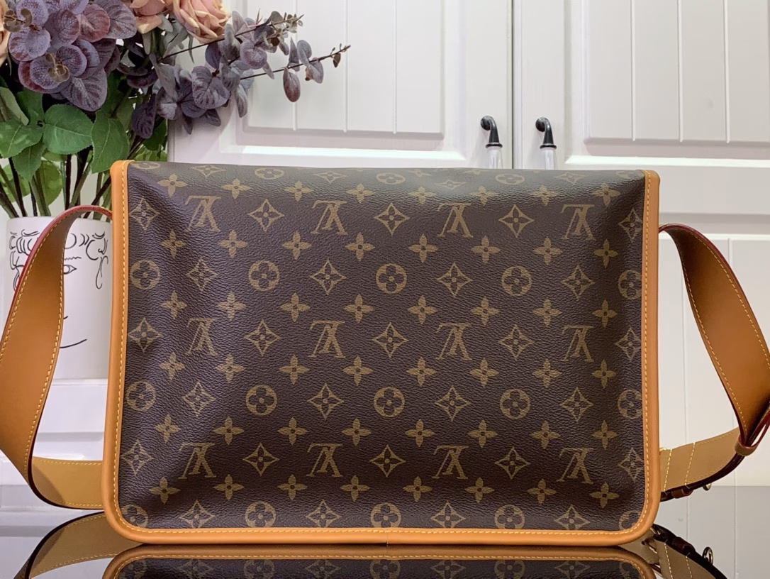 Inspired by the classic Gibecière handbag from the 1990s, the Monogram canvas is trimmed with cowhide leather. The flap closure is equipped with a delicate buckle, and the chic front pocket and padded laptop pocket highlight the functional considerations. The retro style can easily brighten up any look.