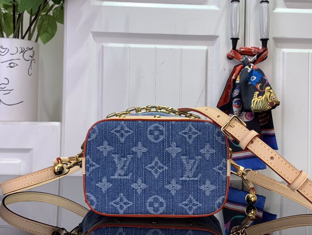The cotton is rendered in a trendy denim hue and then the classic Monogram pattern is laid out on top, contrasting with the leather trims and dazzling chains. The LV inscription decoration on the drawstring closure adds a playful touch and pays tribute to the brand's long-standing heritage