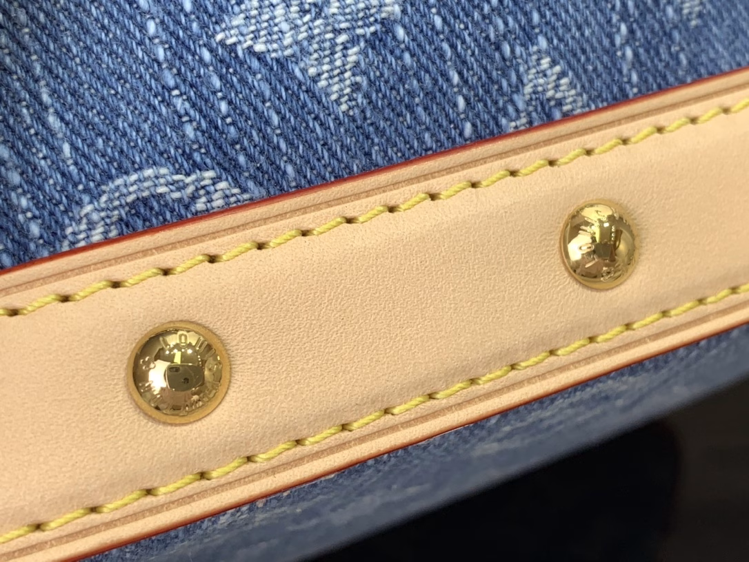 The cotton is rendered in a trendy denim hue and then the classic Monogram pattern is laid out on top, contrasting with the leather trims and dazzling chains. The LV inscription decoration on the drawstring closure adds a playful touch and pays tribute to the brand's long-standing heritage
