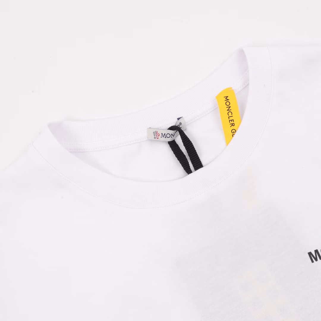 Moncler MC Fujiwara Hiroshi co-branded ring short-sleeved T-shirtMade of double-strand cotton plain fabric. The warp and weft yarns are interwoven in an up-and-down manner to form a uniform checkered texture with a tight but thin structure. Cotton fibers have natural breathability and skin-friendliness. Combined with the pore structure of plain weave, they are suitable for daily perspiration needs while also having good wearing comfort. The yarns have many interlacing points, which enhances the tear resistance and can maintain their shape after multiple washings. Four high-saturation patterns are presented on the fabric through glue printing. The scraper pressure is uniform, and the scraping is divided into 3 times to ensure that the glue is fully penetrated and covered. After high-temperature curing, the pigment is firmly combined with the cotton fiber, and the ink absorption and penetration characteristics of the cotton fiber make the pattern not easy to fall off due to friction. By actively intervening in the shrinkage potential of cotton fibers, the fabric has achieved a leap from volatile to stable, improving dimensional stability, and is not easy to deform or wrinkle. One-to-one customized armband