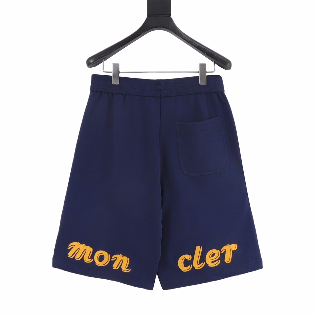 Moncler MC joint large embroidered cotton shortsSingle-sided fish scale fabric woven with cotton as the base, the front is a smooth knitted surface, and the skin-touch surface is formed into a three-dimensional terry loop through the knitting machine's floating thread knitting technology, which increases the fluffiness and delicate touch. The terry loop structure absorbs a lot of water and evaporates quickly, and it is not easy to loosen and deform after multiple washings. The letter LOGO embroidery is formed on the back by the embroidery machine with 16000 needles + 18000 needles. The double-axis linear guide drives the embroidery frame, and the frame moving accuracy can reach 0.01mm/P, ensuring the precise positioning of the embroidery pattern. By actively intervening in the shrinkage potential of cotton fibers, the fabric has achieved a leap from volatile to stable, improving dimensional stability, and is not easy to deform and wrinkle. One-to-one customized joint badges and washing labels