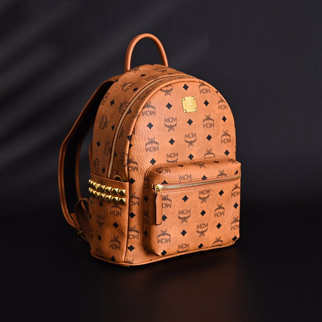MCM Stark Visetos classic monogram double-sided rivet commuting party canvas and leather backpack shoulder bagThis is definitely a treasure model of MCM, popular all over the country, who doesn't know it?This bag is made of classic visetor material, which is very wear-resistant and durableThere are 14 rivets on each side, protruding metal texture, which can be said to be the soul of this bagIt is not picky about clothes, it looks good and versatile when carried. Free your hands, fashionable and practical, and the shape is perfectThe shoulder strap of this bag adopts an adjustable design. No matter what kind of body shape, it can be adjusted according to yourself, and everyone can control it perfectlyThe overall texture is very textured, like a work of art, very delicateThe appearance rate is too high, the walking grass king, looking back and smiling to fascinate everyoneFashionable style, versatile style, love without waitingPlay various occasions, suitable for all fashionable men and women