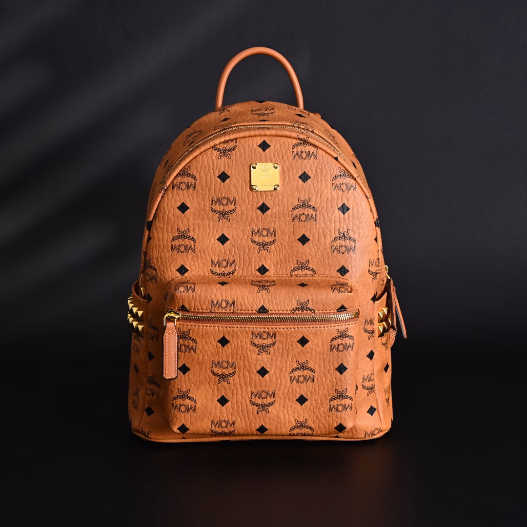 MCM Stark Visetos classic monogram double-sided rivet commuting party canvas and leather backpack shoulder bagThis is definitely a treasure model of MCM, popular all over the country, who doesn't know it?This bag is made of classic visetor material, which is very wear-resistant and durableThere are 14 rivets on each side, protruding metal texture, which can be said to be the soul of this bagIt is not picky about clothes, it looks good and versatile when carried. Free your hands, fashionable and practical, and the shape is perfectThe shoulder strap of this bag adopts an adjustable design. No matter what kind of body shape, it can be adjusted according to yourself, and everyone can control it perfectlyThe overall texture is very textured, like a work of art, very delicateThe appearance rate is too high, the walking grass king, looking back and smiling to fascinate everyoneFashionable style, versatile style, love without waitingPlay various occasions, suitable for all fashionable men and women