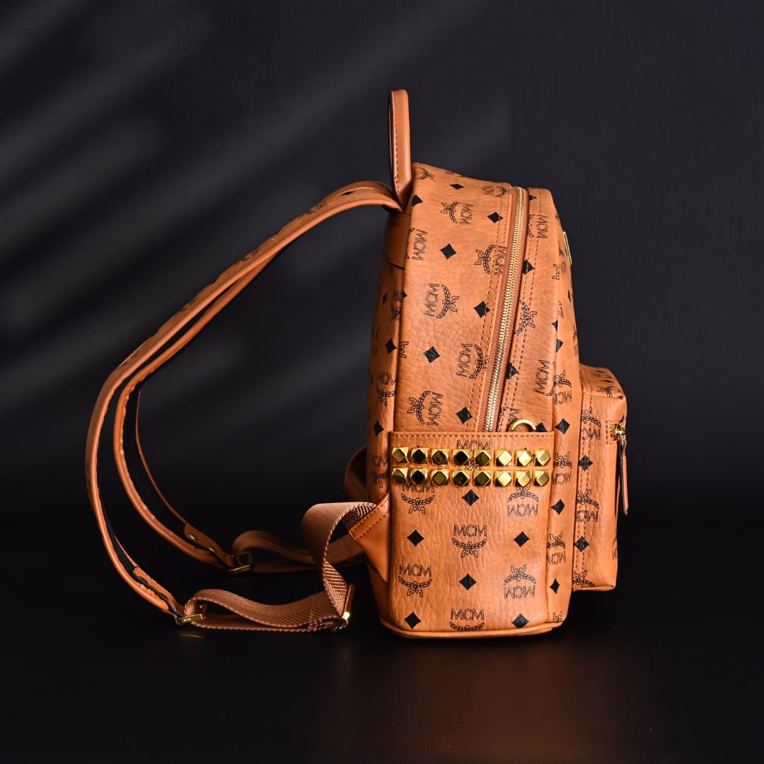 MCM Stark Visetos classic monogram double-sided rivet commuting party canvas and leather backpack shoulder bagThis is definitely a treasure model of MCM, popular all over the country, who doesn't know it?This bag is made of classic visetor material, which is very wear-resistant and durableThere are 14 rivets on each side, protruding metal texture, which can be said to be the soul of this bagIt is not picky about clothes, it looks good and versatile when carried. Free your hands, fashionable and practical, and the shape is perfectThe shoulder strap of this bag adopts an adjustable design. No matter what kind of body shape, it can be adjusted according to yourself, and everyone can control it perfectlyThe overall texture is very textured, like a work of art, very delicateThe appearance rate is too high, the walking grass king, looking back and smiling to fascinate everyoneFashionable style, versatile style, love without waitingPlay various occasions, suitable for all fashionable men and women