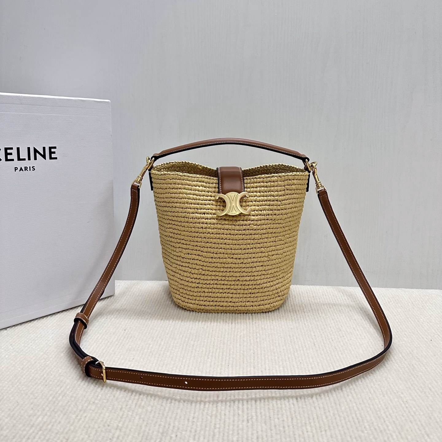 LOUISE Mini Bucket BagMini bag, this model can fit larger smartphones such as PLUSVegetable materialUnlinedGold finishHand, shoulder and crossbodyLeather flap with TRIOMPHE magnetic clasp
