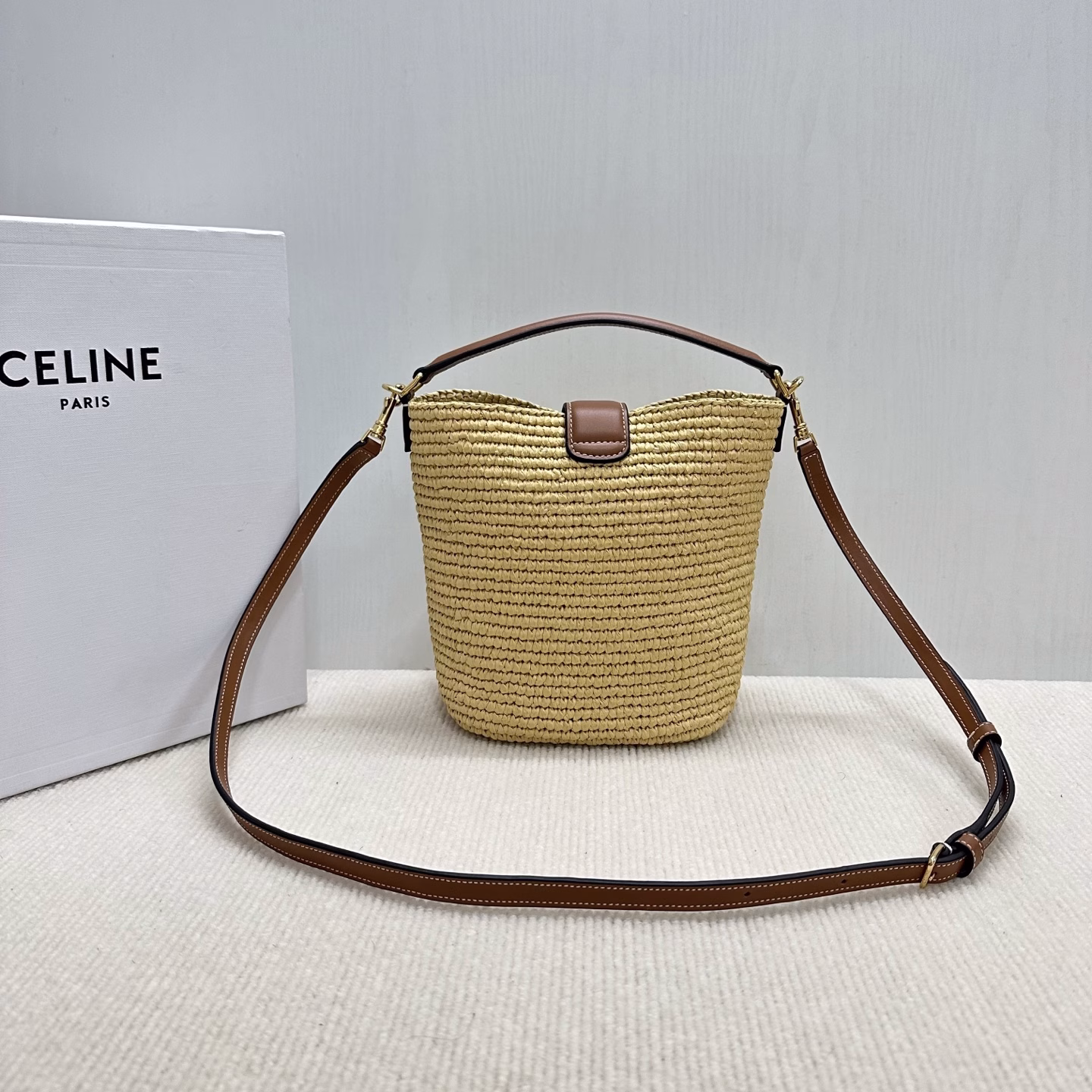 LOUISE Mini Bucket BagMini bag, this model can fit larger smartphones such as PLUSVegetable materialUnlinedGold finishHand, shoulder and crossbodyLeather flap with TRIOMPHE magnetic clasp