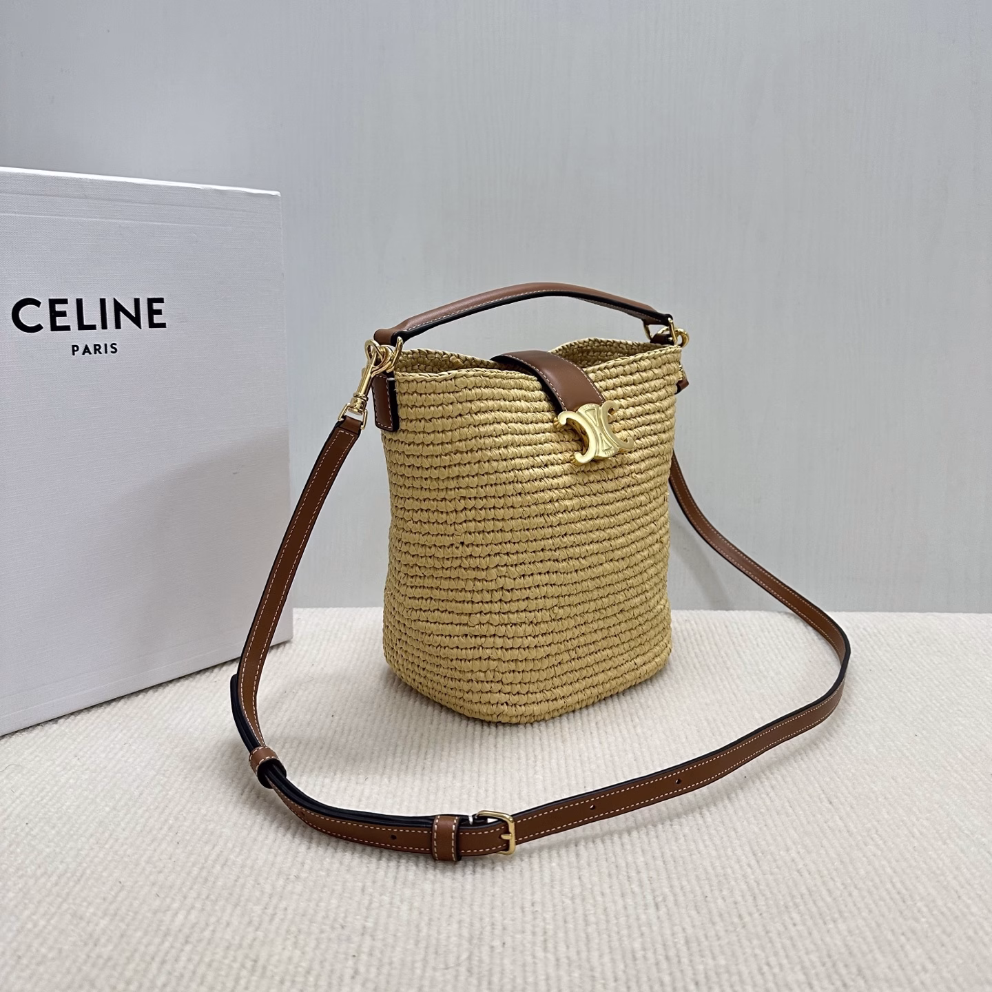 LOUISE Mini Bucket BagMini bag, this model can fit larger smartphones such as PLUSVegetable materialUnlinedGold finishHand, shoulder and crossbodyLeather flap with TRIOMPHE magnetic clasp