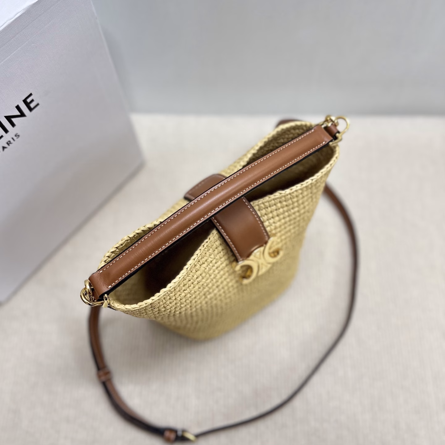 LOUISE Mini Bucket BagMini bag, this model can fit larger smartphones such as PLUSVegetable materialUnlinedGold finishHand, shoulder and crossbodyLeather flap with TRIOMPHE magnetic clasp