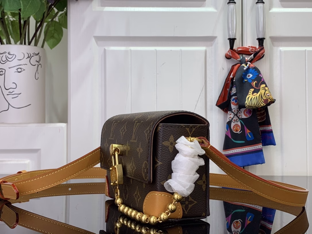 The Steamer Mini Bag is crafted from Monogram canvas with distressed calfskin trim and striking hardware. The new square lock recalls Pharrell Williams' signature Damier motif, the delicate key connects to the delicate bead chain, and the adjustable strap allows for shoulder and crossbody wear.