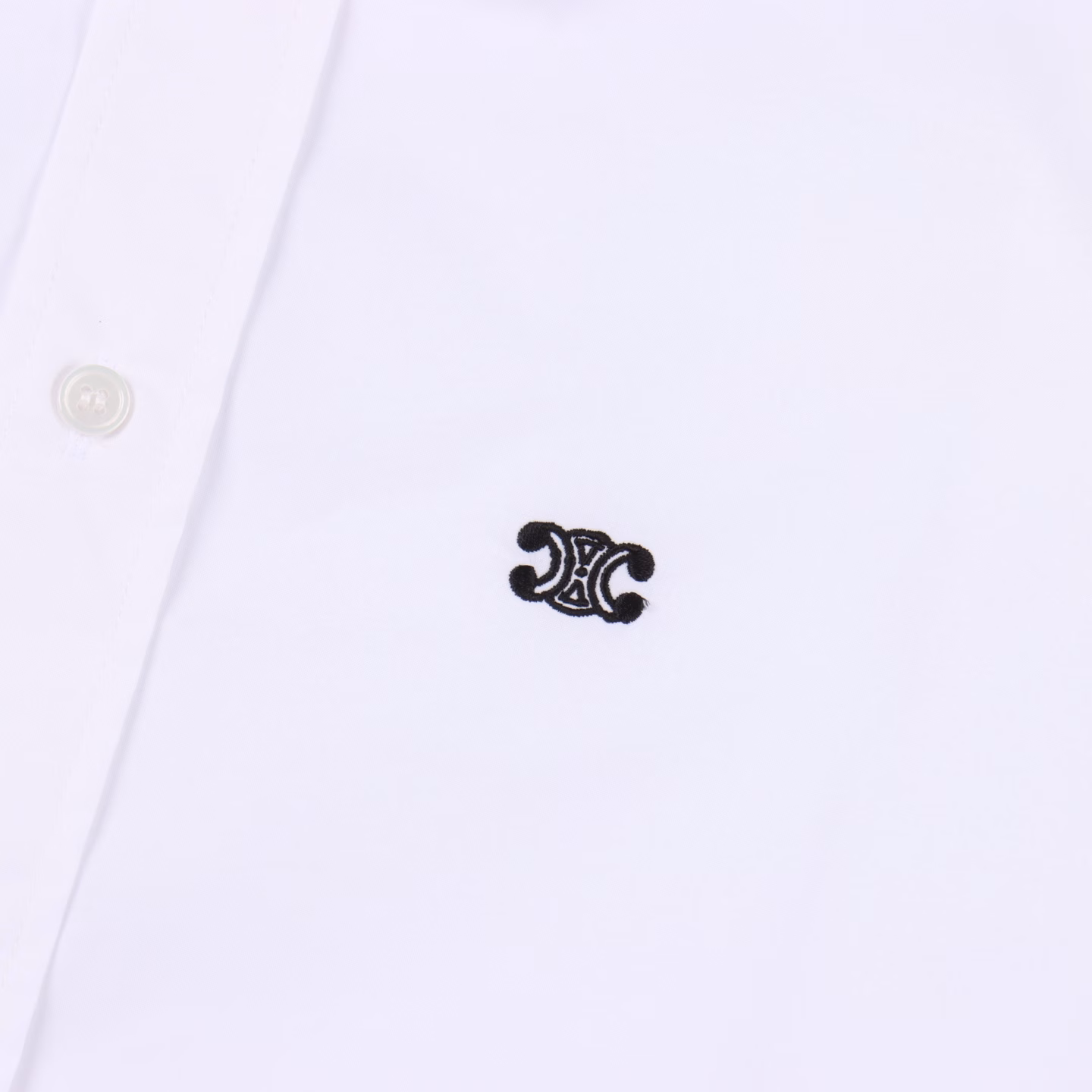 Celine CE long-sleeved shirt with Arc de Triomphe logo embroidery on the hemThe fabric is made of high-count cotton yarn with high warp density and low weft density. The single-color flat embroidery on the front piece is controlled by the high-precision calculation system of the computer embroidery machine to coordinate the machine head, needle bar, and bobbin. The fabric frame moves accurately in the horizontal and vertical directions to form the stitch track, adjust the tension of the upper and lower threads, ensure that the stitches are flat and without floating threads, and form a fine pattern with an error of ±0.1mm. The ironer turns the collar up, irons it from the bottom to the top with high-temperature wet steam, applies pressure to smooth the wrinkles, and then turns it over to the front and repeats the operation. Turn to the neckline to iron out the arc, and press the back collar to the bottom to keep it straight. The shoulder and sleeve part uses the hanging method to avoid pressing the edge. After adjusting the fiber density through the ironer's 