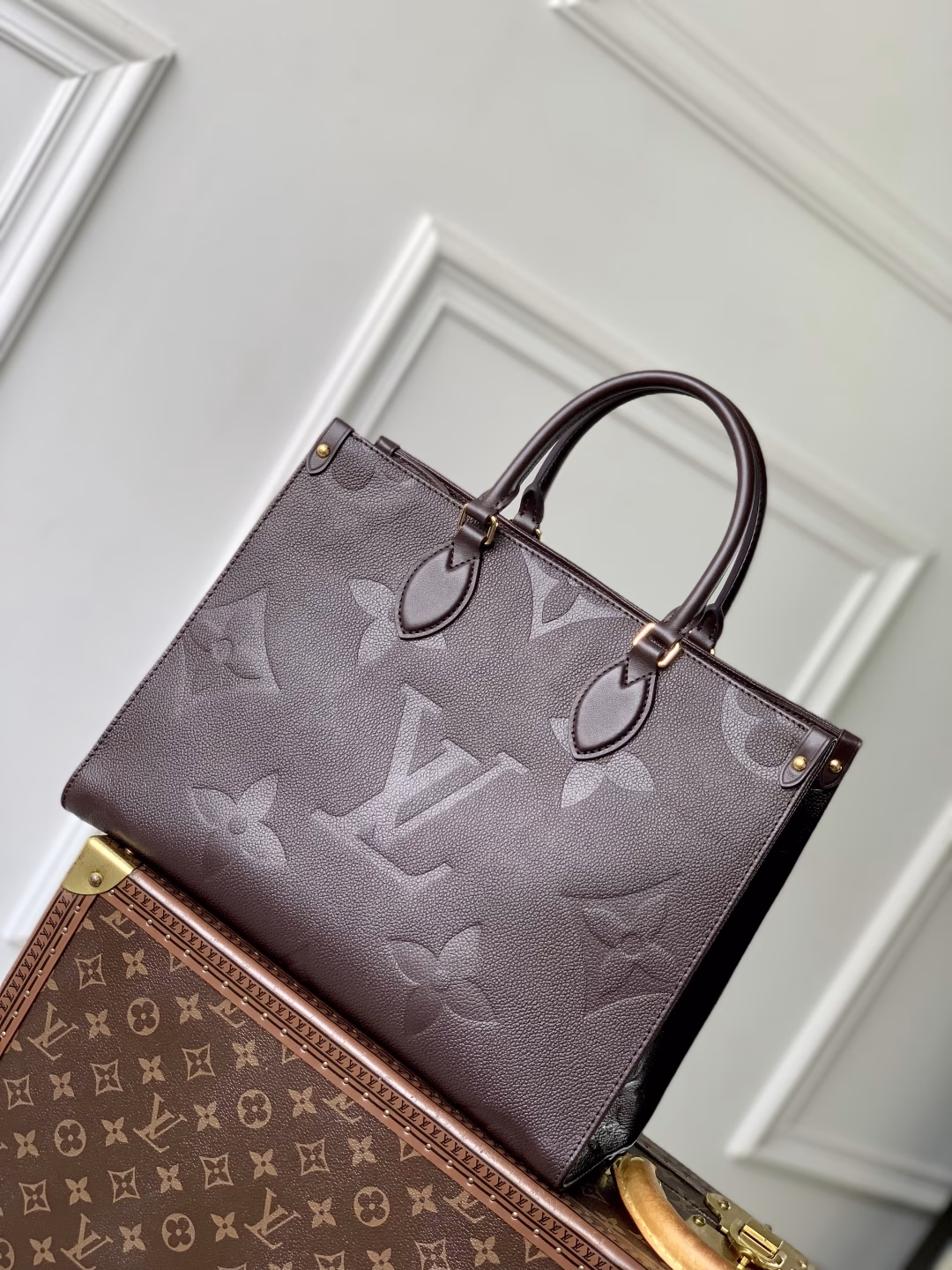 This OnTheGo Medium Bag is made of Epi leather with a Monogram pattern and shiny hardware. It has a spacious interior with multiple pockets that can easily accommodate a laptop and a large phone, making it a great choice for daily commuting and weekend trips.