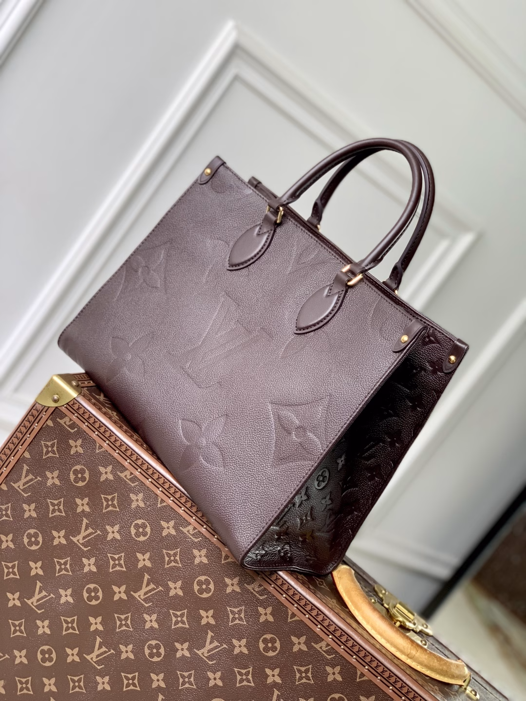 This OnTheGo Medium Bag is made of Epi leather with a Monogram pattern and shiny hardware. It has a spacious interior with multiple pockets that can easily accommodate a laptop and a large phone, making it a great choice for daily commuting and weekend trips.