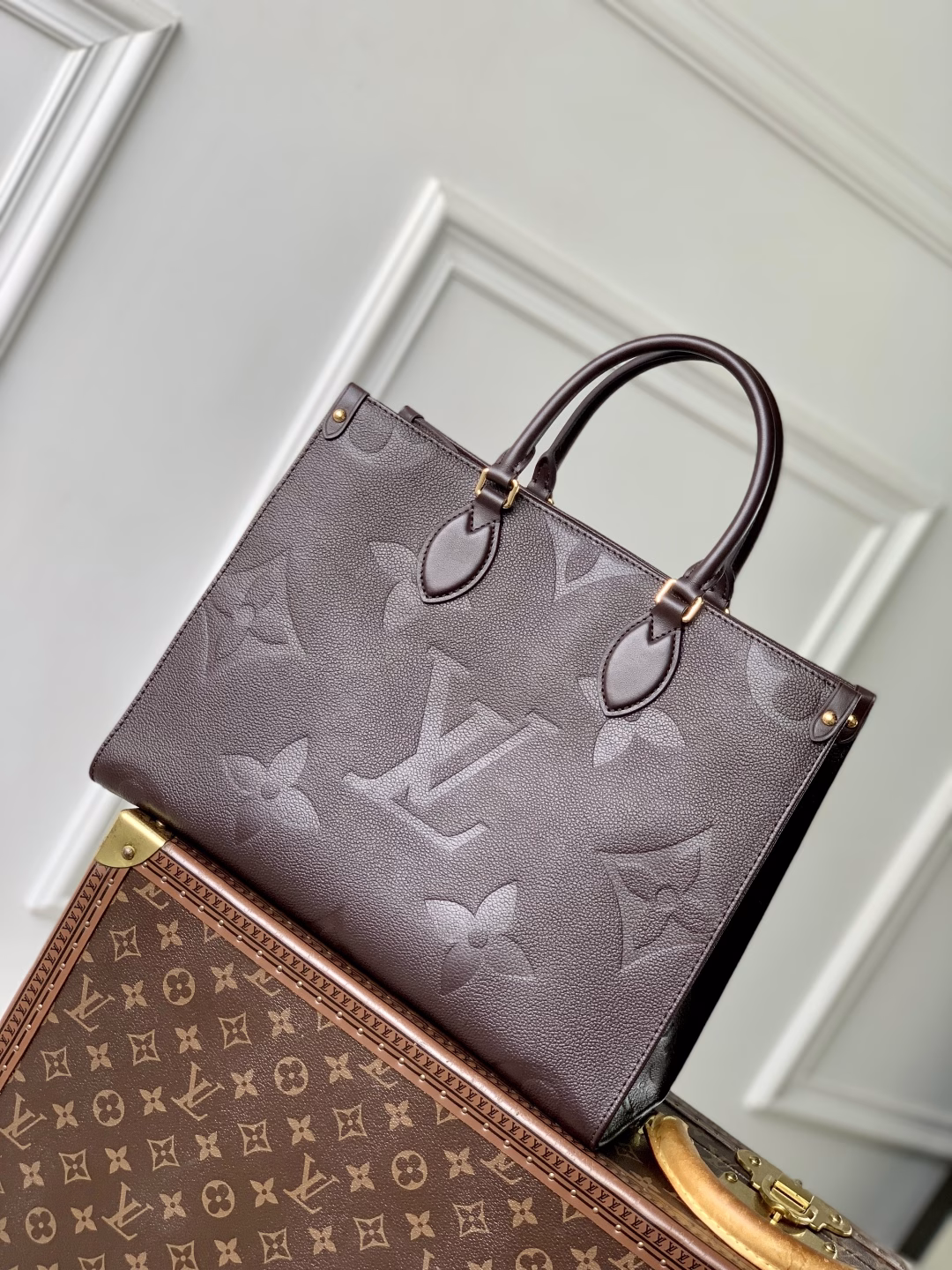 This OnTheGo Medium Bag is made of Epi leather with a Monogram pattern and shiny hardware. It has a spacious interior with multiple pockets that can easily accommodate a laptop and a large phone, making it a great choice for daily commuting and weekend trips.