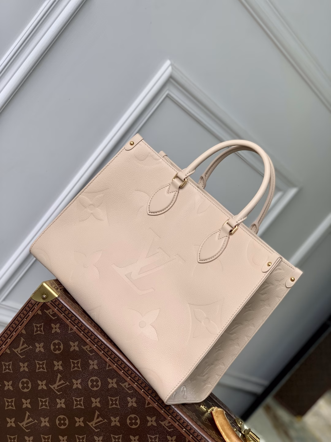 This OnTheGo Medium Bag is made of Epi leather with a Monogram pattern and shiny hardware. It has a spacious interior with multiple pockets that can easily accommodate a laptop and a large phone, making it a great choice for daily commuting and weekend trips.