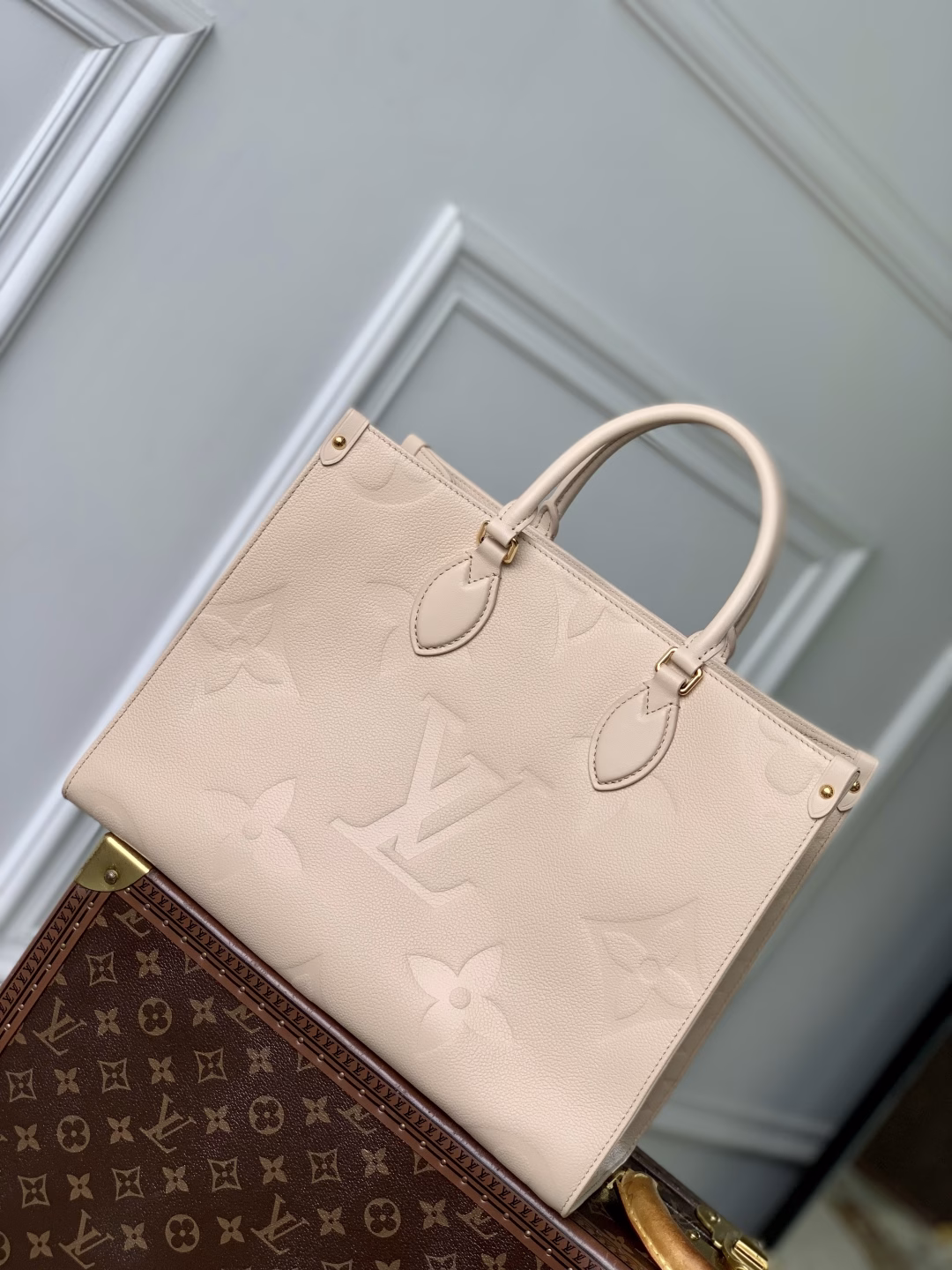 This OnTheGo Medium Bag is made of Epi leather with a Monogram pattern and shiny hardware. It has a spacious interior with multiple pockets that can easily accommodate a laptop and a large phone, making it a great choice for daily commuting and weekend trips.