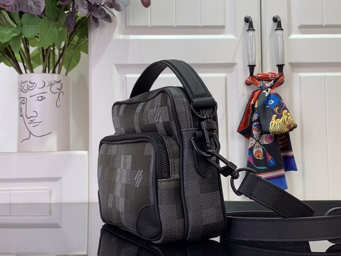 The Nil messenger bag is made from Pharrell Williams's reinterpretation of Damoflage Black coated canvas, combining the designer's fresh perspective with the brand's heritage to create a camouflage-like pixelated Damier pattern. A zip front pocket and main compartment complete the functional configuration.