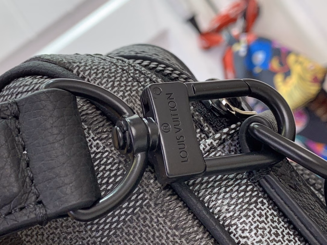 The Nil messenger bag is made from Pharrell Williams's reinterpretation of Damoflage Black coated canvas, combining the designer's fresh perspective with the brand's heritage to create a camouflage-like pixelated Damier pattern. A zip front pocket and main compartment complete the functional configuration.