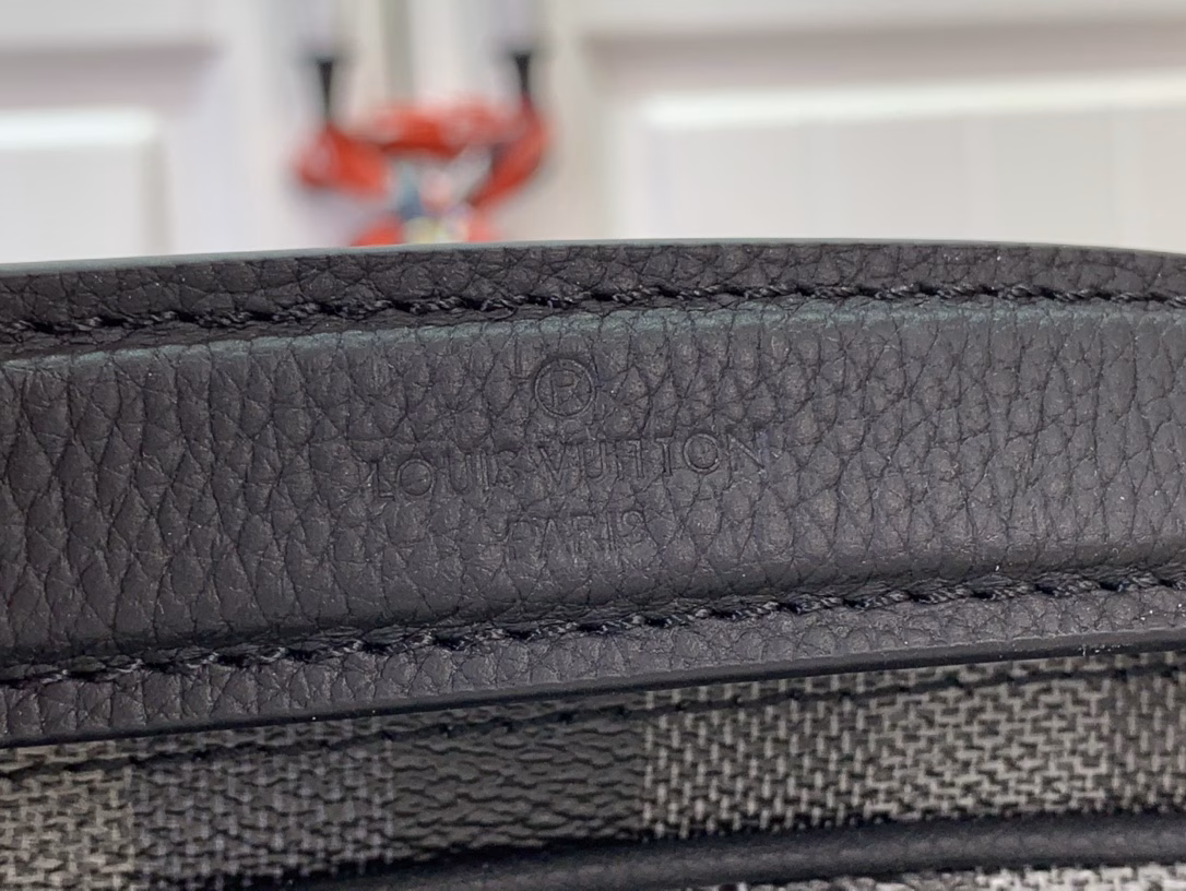 The Nil messenger bag is made from Pharrell Williams's reinterpretation of Damoflage Black coated canvas, combining the designer's fresh perspective with the brand's heritage to create a camouflage-like pixelated Damier pattern. A zip front pocket and main compartment complete the functional configuration.