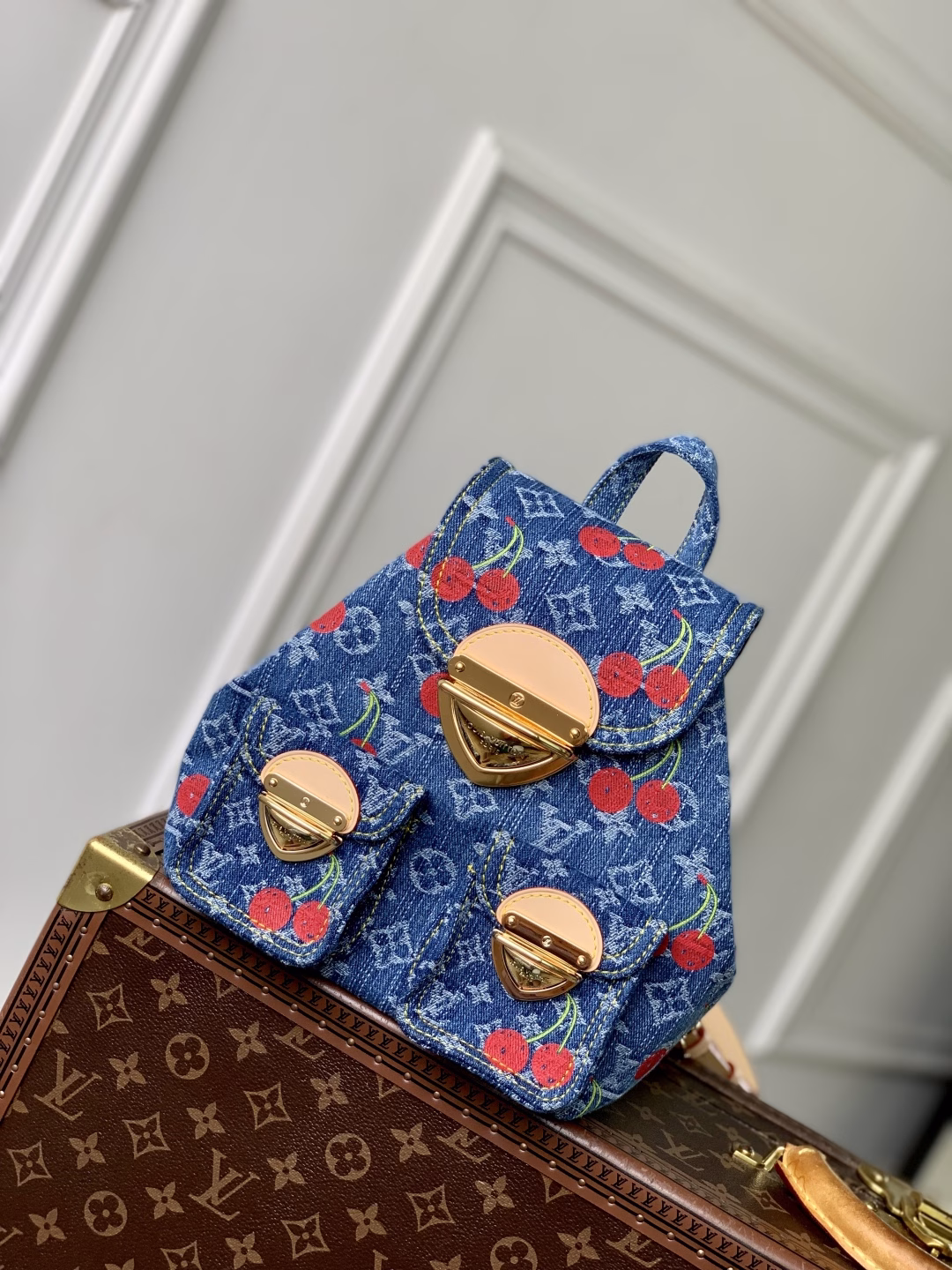 This playful re-interpretation of the Louis Vuitton x Murakami Venice backpack is a joyful addition to the collection. Made from Monogram denim, the backpack features a unique embroidered cherry pattern inspired by the colorful aesthetic of Japanese artist Takashi Murakami. The slim shoulder straps are trimmed with striking natural cowhide, while the flap and two exterior patch pockets feature oversized gold-tone latches.