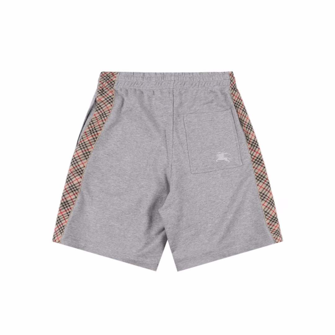 Burberry BBR Knight Side Plaid ShortsSingle-sided fish scale fabric woven with cotton as the base, the front is a smooth knitted surface, and the skin-touch surface is formed into a three-dimensional terry loop through the floating thread knitting technology of the knitting machine, which increases the fluffiness and delicate touch. The terry loop structure absorbs a large amount of water and evaporates quickly, and it is not easy to loosen and deform after multiple washings. The single-color flat embroidery on the back patch pocket body is controlled by the high-precision calculation system of the computer embroidery machine to control the coordinated operation of the machine head, needle bar, and bobbin. The fabric frame moves accurately in the horizontal and vertical directions to form a stitch track, adjust the tension of the upper and lower threads, ensure that the stitches are flat and free of floating threads, and form a fine pattern with an error of ±0.1mm. The fabric is evenly humidified by steam, squeezed with a heated roller and an elastic rubber blanket to force the fibers to shrink, and finally fixed by cooling with cold air. After treatment, the shrinkage rate is controlled within 3%, and the drawstring head is customized one to one