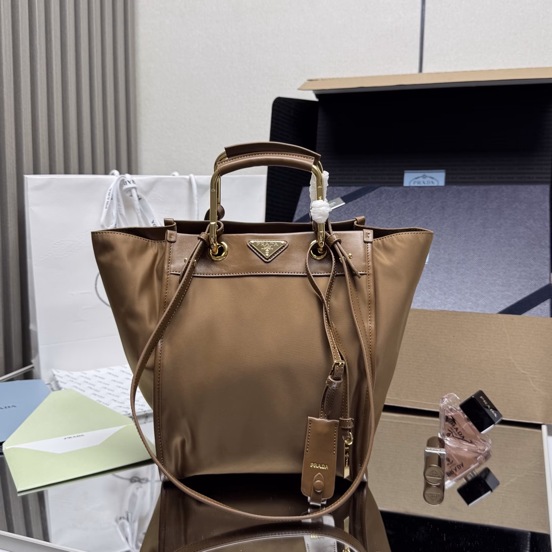 This tote bag features a stylish geometric shape, combining practical Re-Nylon recycled nylon material with exquisite details. The shape is changeable, with metal and leather double handles, which can be switched between handbag and shoulder bag at will. The iconic enameled triangular metal logo is embellished. It has a large capacity and is a timeless hit. 🎉 Babies, hurry up and get it