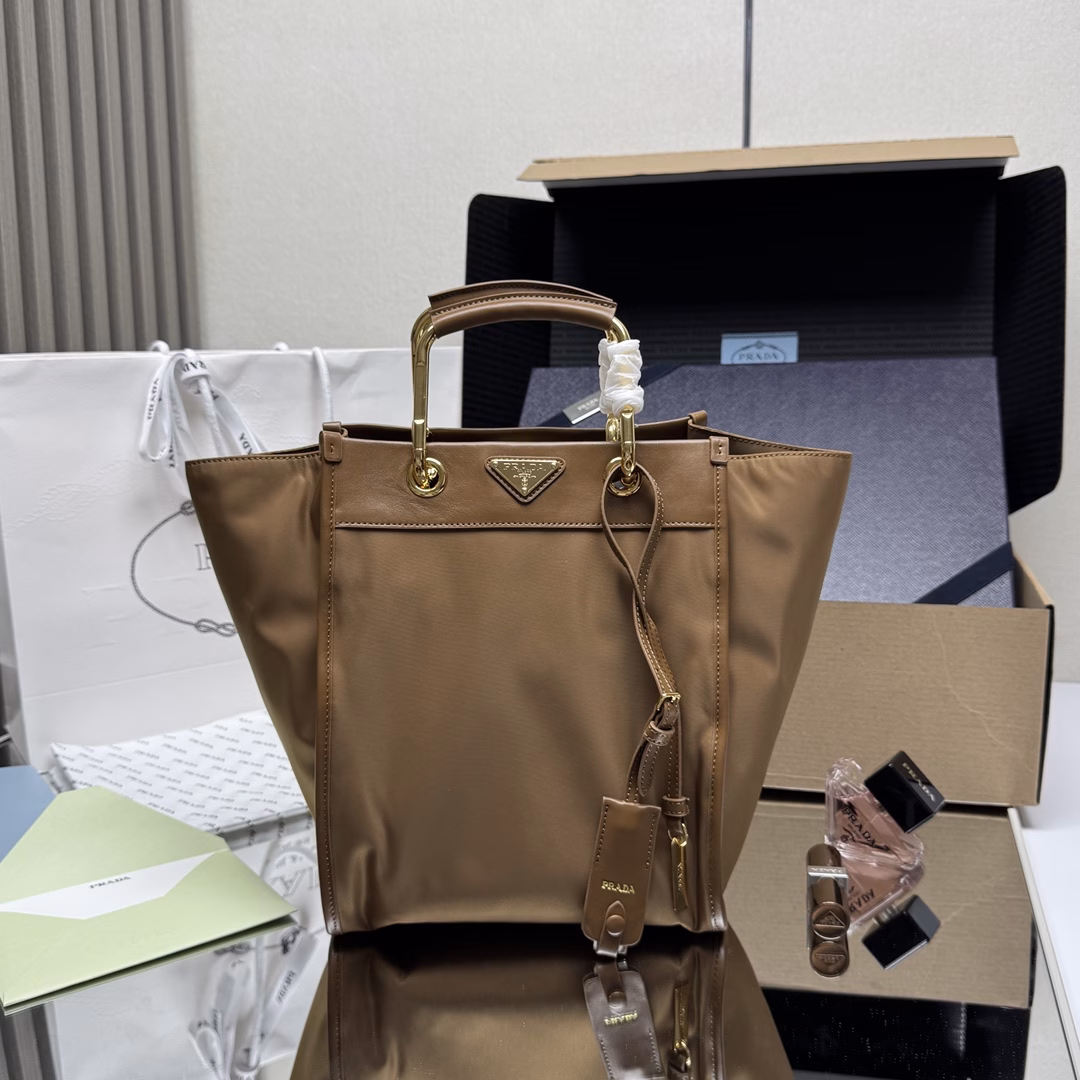 This tote bag features a stylish geometric shape, combining practical Re-Nylon recycled nylon material with exquisite details. The shape is changeable, with metal and leather double handles, which can be switched between handbag and shoulder bag at will. The iconic enameled triangular metal logo is embellished. It has a large capacity and is a timeless hit. 🎉 Babies, hurry up and get it