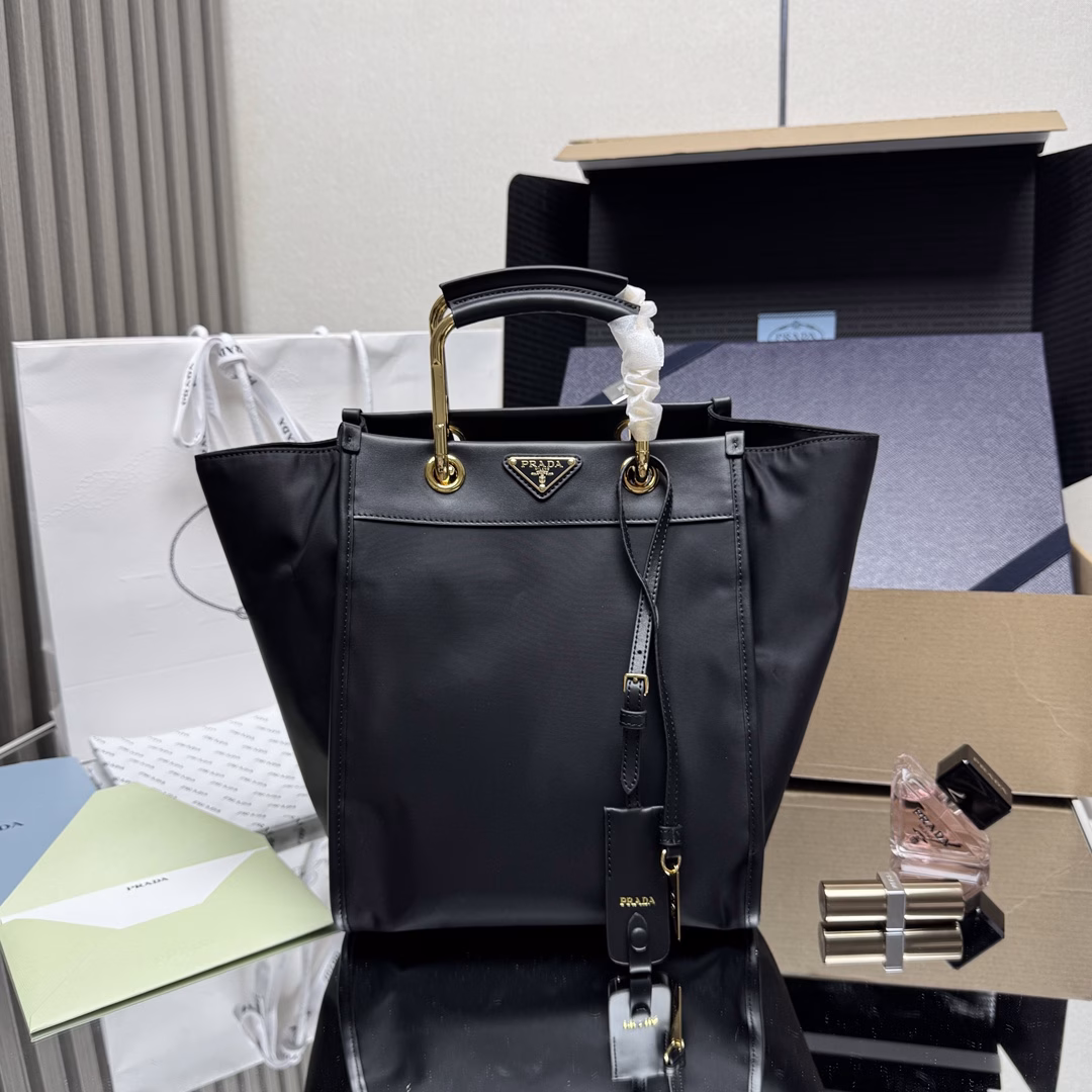 This tote bag features a stylish geometric shape, combining practical Re-Nylon recycled nylon material with exquisite details. The shape is changeable, with metal and leather double handles, which can be switched between handbag and shoulder bag at will. The iconic enameled triangular metal logo is embellished. It has a large capacity and is a timeless hit. 🎉 Babies, hurry up and get it