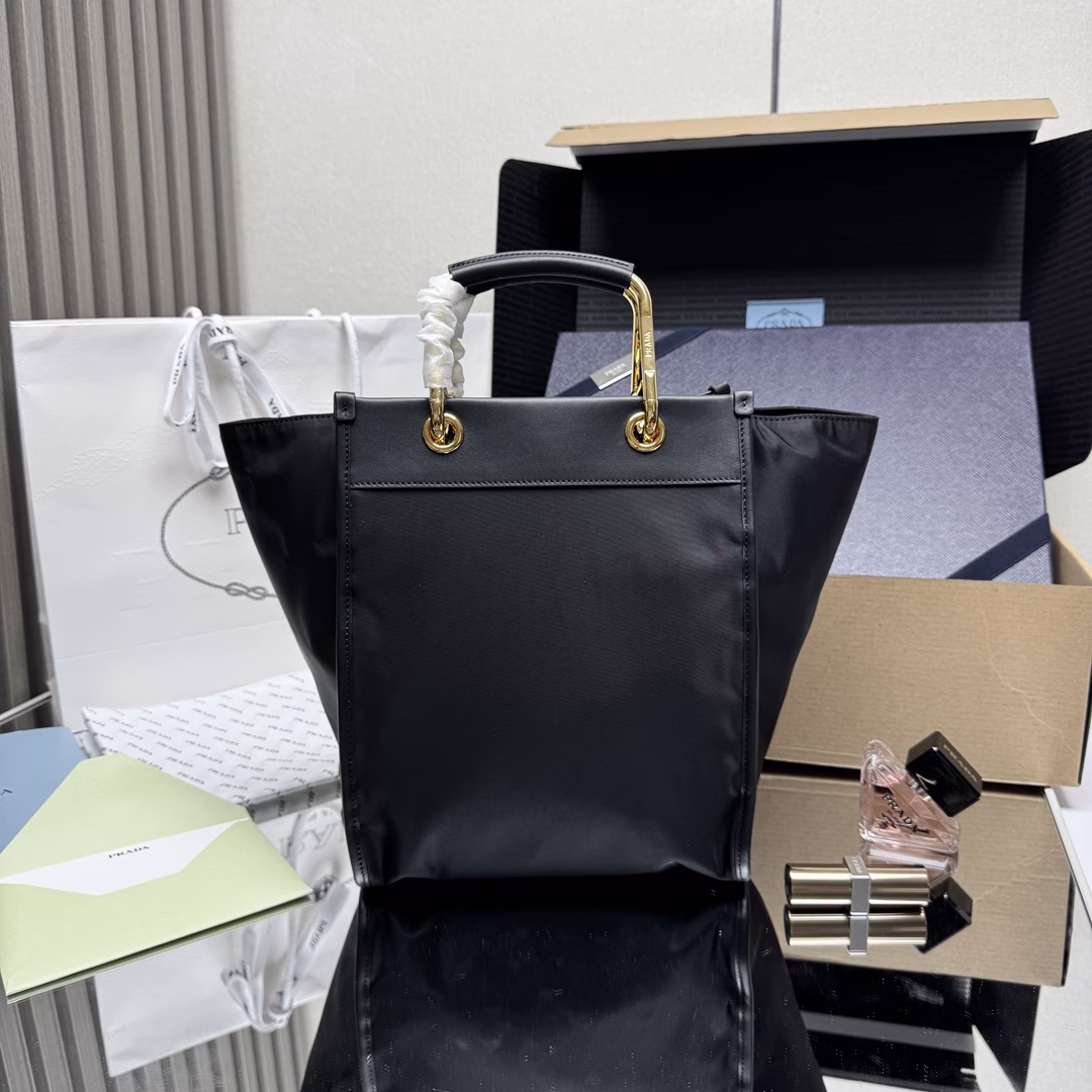 This tote bag features a stylish geometric shape, combining practical Re-Nylon recycled nylon material with exquisite details. The shape is changeable, with metal and leather double handles, which can be switched between handbag and shoulder bag at will. The iconic enameled triangular metal logo is embellished. It has a large capacity and is a timeless hit. 🎉 Babies, hurry up and get it