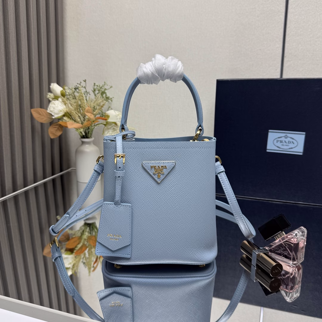 Saffiano leather Leather handles Detachable and adjustable leather shoulder strap Detachable leather name tag with metal logo Leather-covered center opening with magnetic closure Saffiano leather triangle logo Contrast nappa leather lining