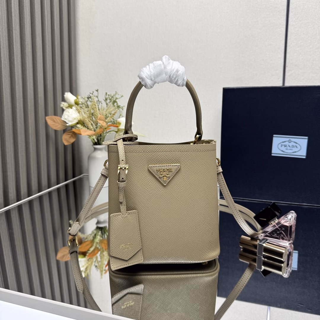Saffiano leather Leather handles Detachable and adjustable leather shoulder strap Detachable leather name tag with metal logo Leather-covered center opening with magnetic closure Saffiano leather triangle logo Contrast nappa leather lining