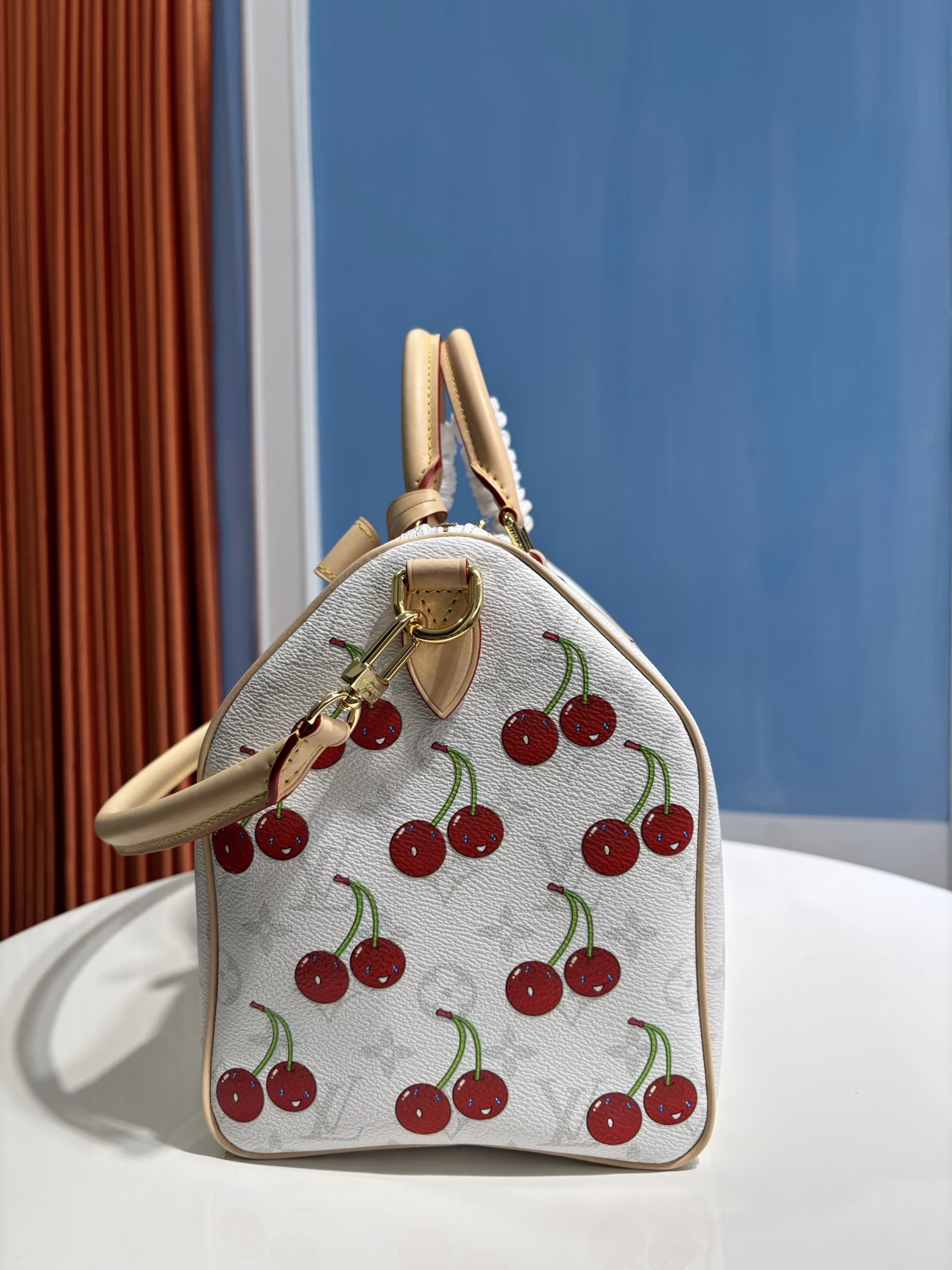 The Speedy Soft 30 bag is inspired by the Louis Vuitton x Takashi Murakami remake. The Monogram coated canvas is presented in a muted color palette to highlight the vibrant cherry pattern created by the Japanese artist. The denim interior, the Toron top handle and detachable Toron shoulder strap are made from leather, and the bow-shaped key holder is a rich detail.