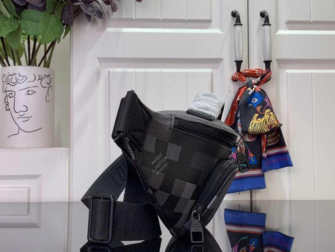 The Rush waist bag is crafted in Damoflage Black canvas with a pixelated Damier graphic overlaid for a camouflage effect. The adjustable strap allows for comfortable waist, shoulder or crossbody wear.