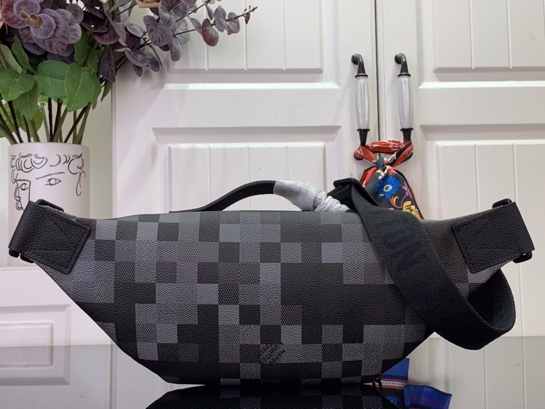 The Rush waist bag is crafted in Damoflage Black canvas with a pixelated Damier graphic overlaid for a camouflage effect. The adjustable strap allows for comfortable waist, shoulder or crossbody wear.