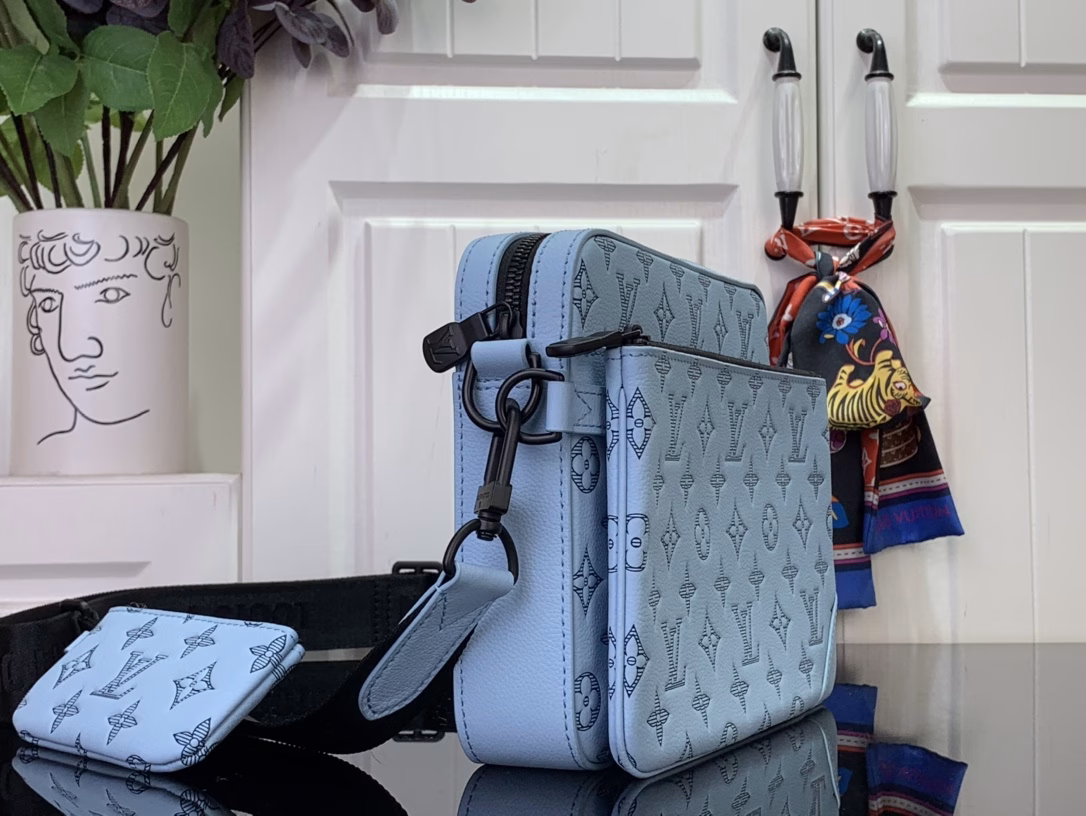 This Trio messenger bag is made of Monogram embossed cowhide leather. The zippered front pocket and the small coin purse on the shoulder strap are both detachable, which enriches the functional design with the main compartment. The detachable and adjustable jacquard fabric shoulder strap is marked with the brand logo, making it comfortable to carry on the shoulder or crossbody.