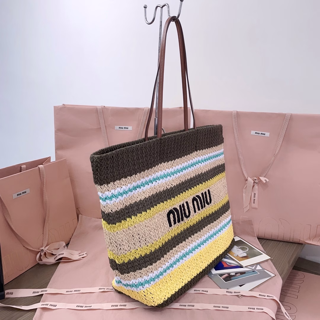 This imported Lafite straw woven cotton-padded tote bag features a fresh and pleasant blue tone. The unique weaving texture adds a touch of retro charm, making it both high-end and girlish. The front is adorned with the signature MiuMiu embroidery. The interior is made of cotton fabric, which is extremely light and has a large capacity. It is a must-have for outings and suitable for all seasons. The actual item is super beautiful